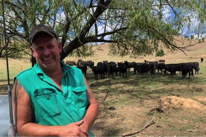 Michael Ryan poses in front of his herd of cows